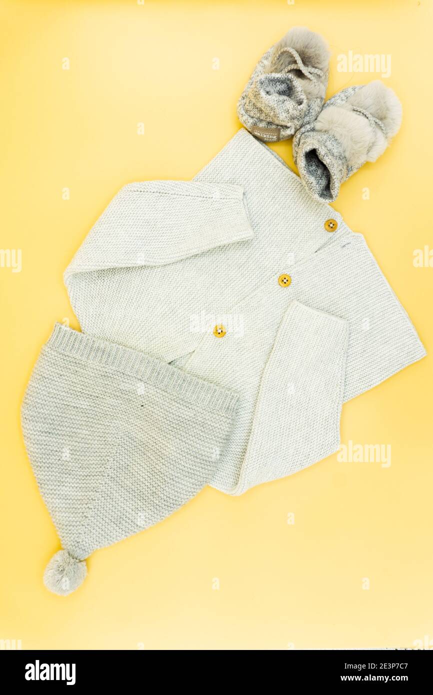 top view of winter baby clothes on orange background. sweater pants and shoes. baby fashion concept. flat lay flat design. copy space Stock Photo