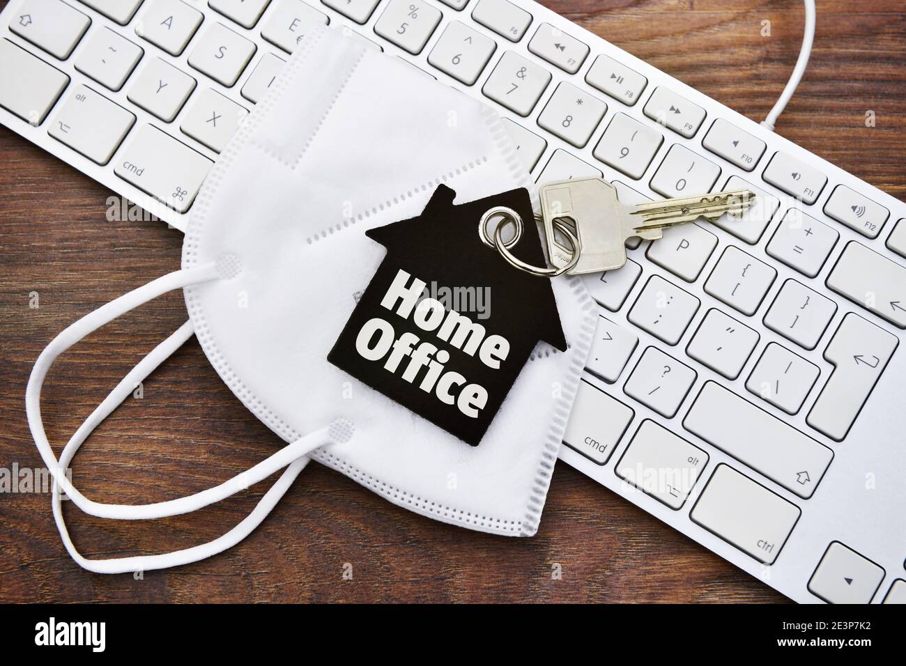 Home office key ring, face mask and computer keyboard Stock Photo