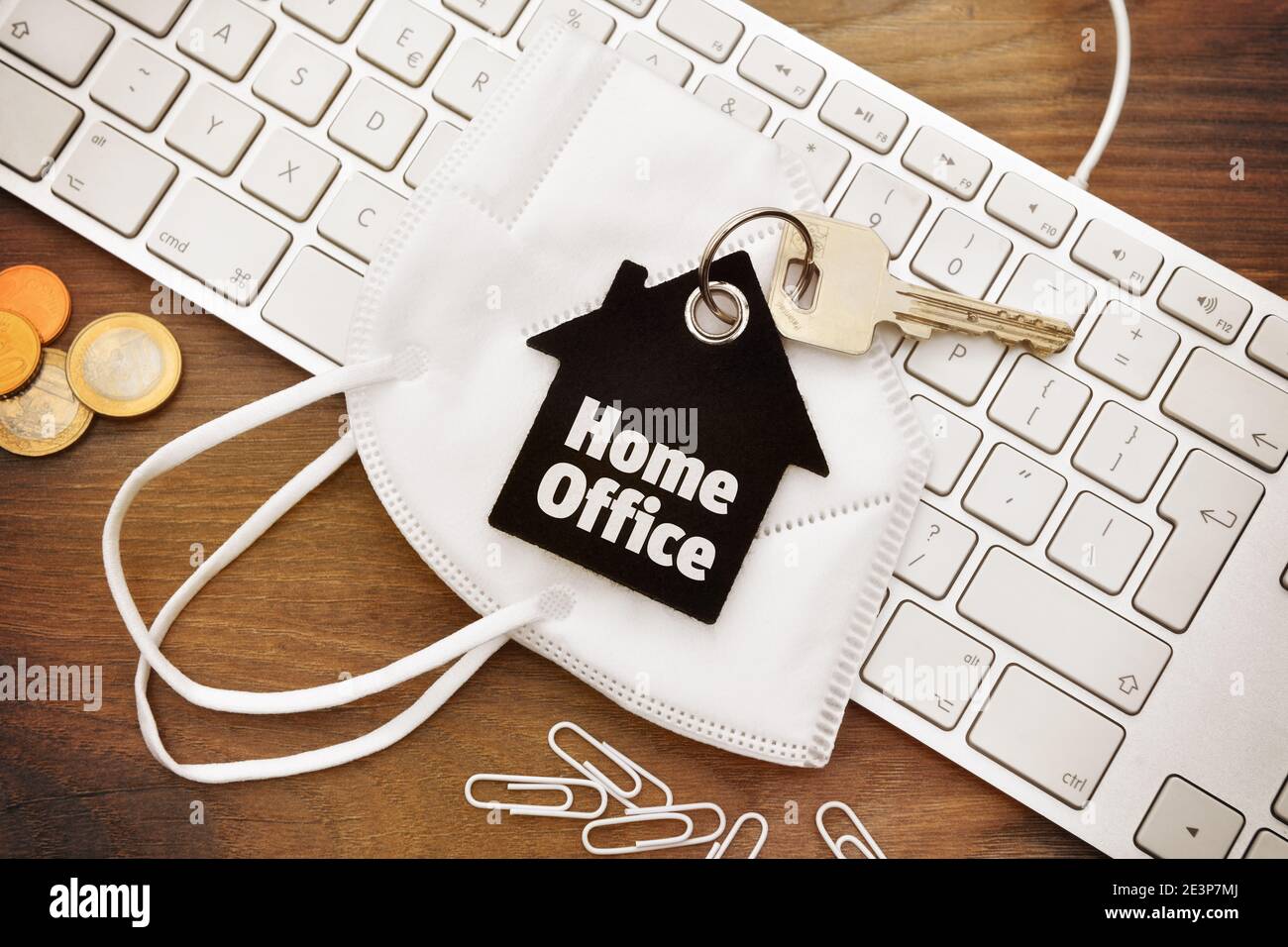 Home office key ring, face mask and computer keyboard Stock Photo