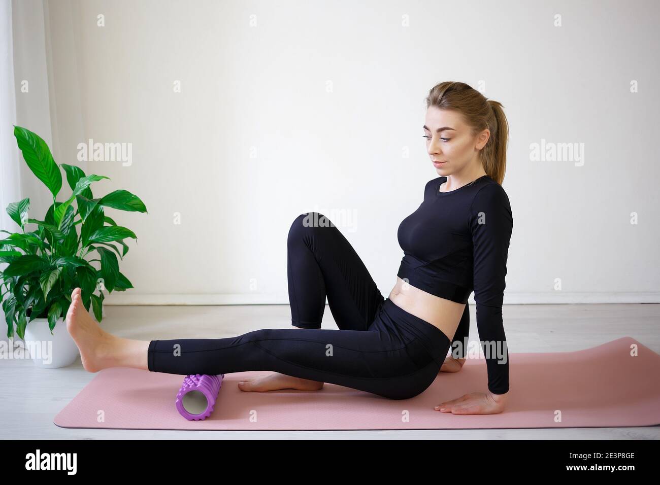 https://c8.alamy.com/comp/2E3P8GE/young-woman-doing-exercises-on-a-massage-roller-2E3P8GE.jpg