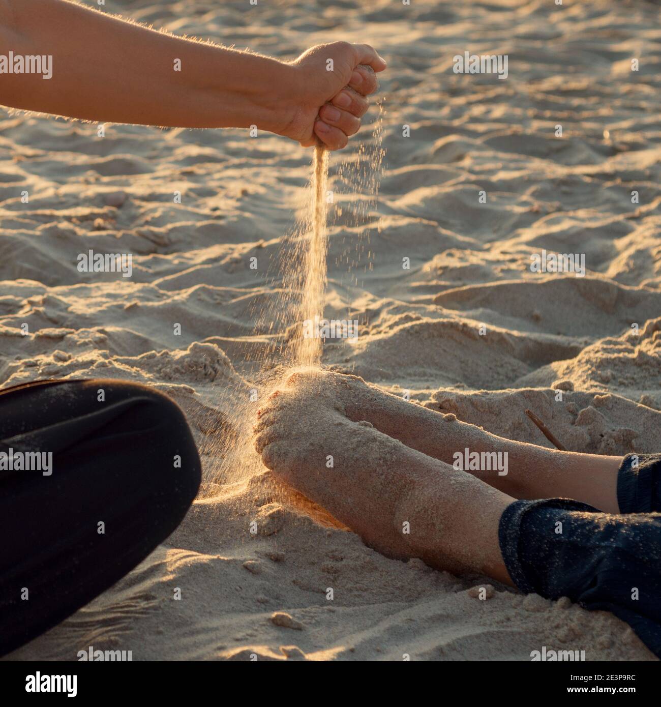 Hand pouring sand on his feet Stock Photo - Alamy