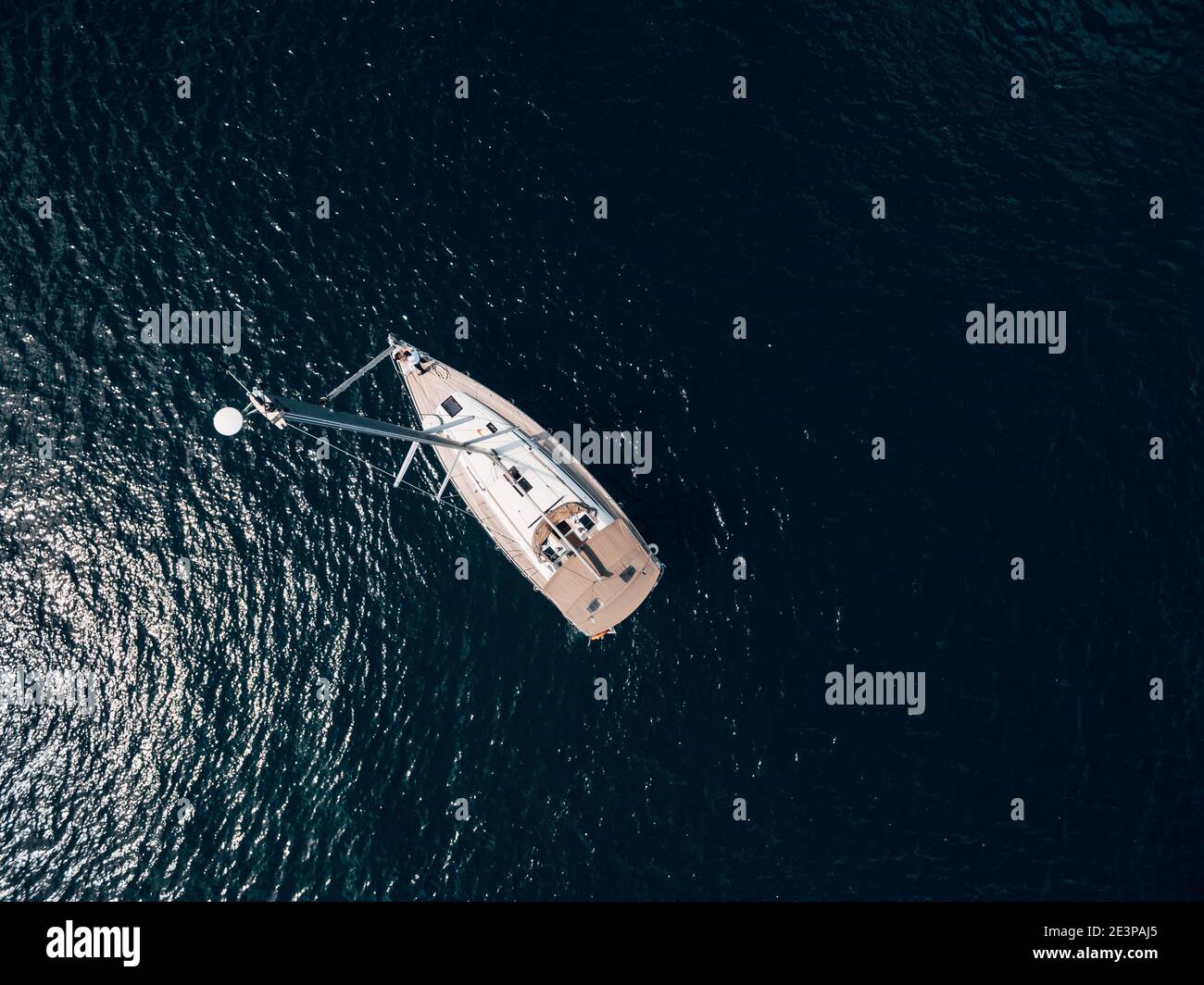 Aerial top view of a sailing yacht with a high mast floating on the ...