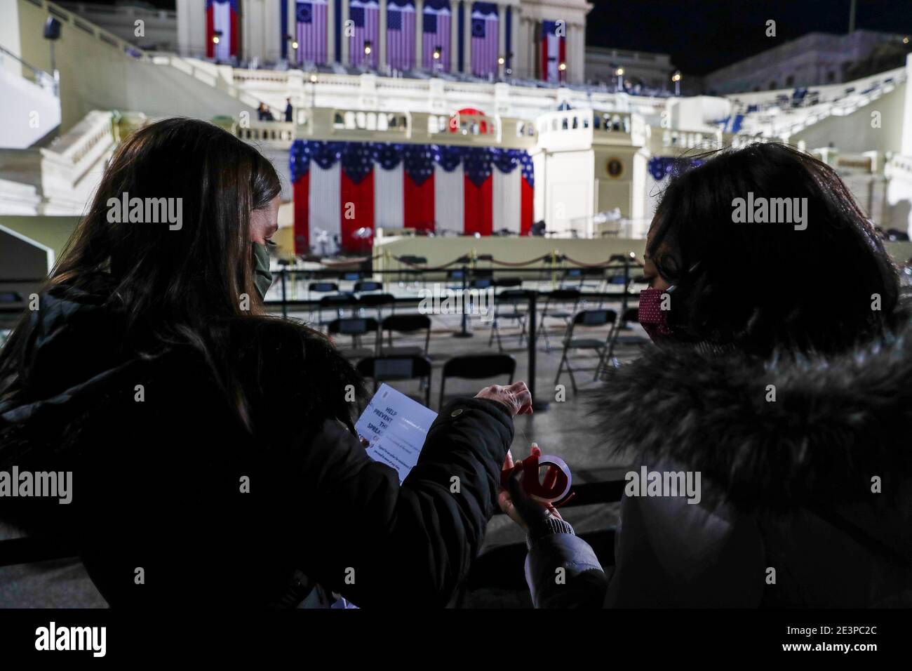 Staff members put out COVID-19 information signs in the seating area before Joe Biden's presidential inauguration in Washington, U.S., January 20, 2021. REUTERS/Jim Bourg Stock Photo