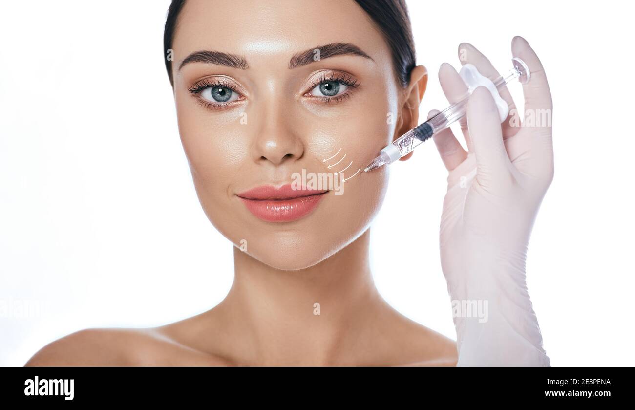 Beautician doing injection into the nasolabial folds. Correction of wrinkles on the female face using dermal fillers Stock Photo