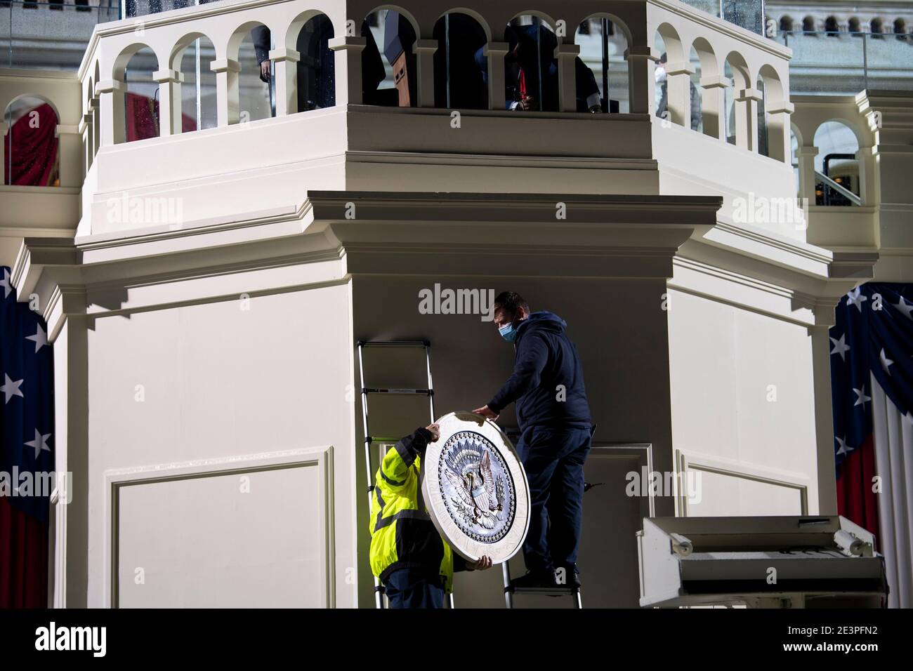 UNITED STATES - January 20: Architect of the Capitol workers hang up a Presidential seal as preparations are made prior to the 59th inaugural ceremony for President-elect Joe Biden and Vice President-elect Kamala Harris on the West Front of the U.S. Capitol in Washington on Wednesday, Jan. 20, 2021. Credit: Caroline Brehman / Pool via CNP | usage worldwide Stock Photo