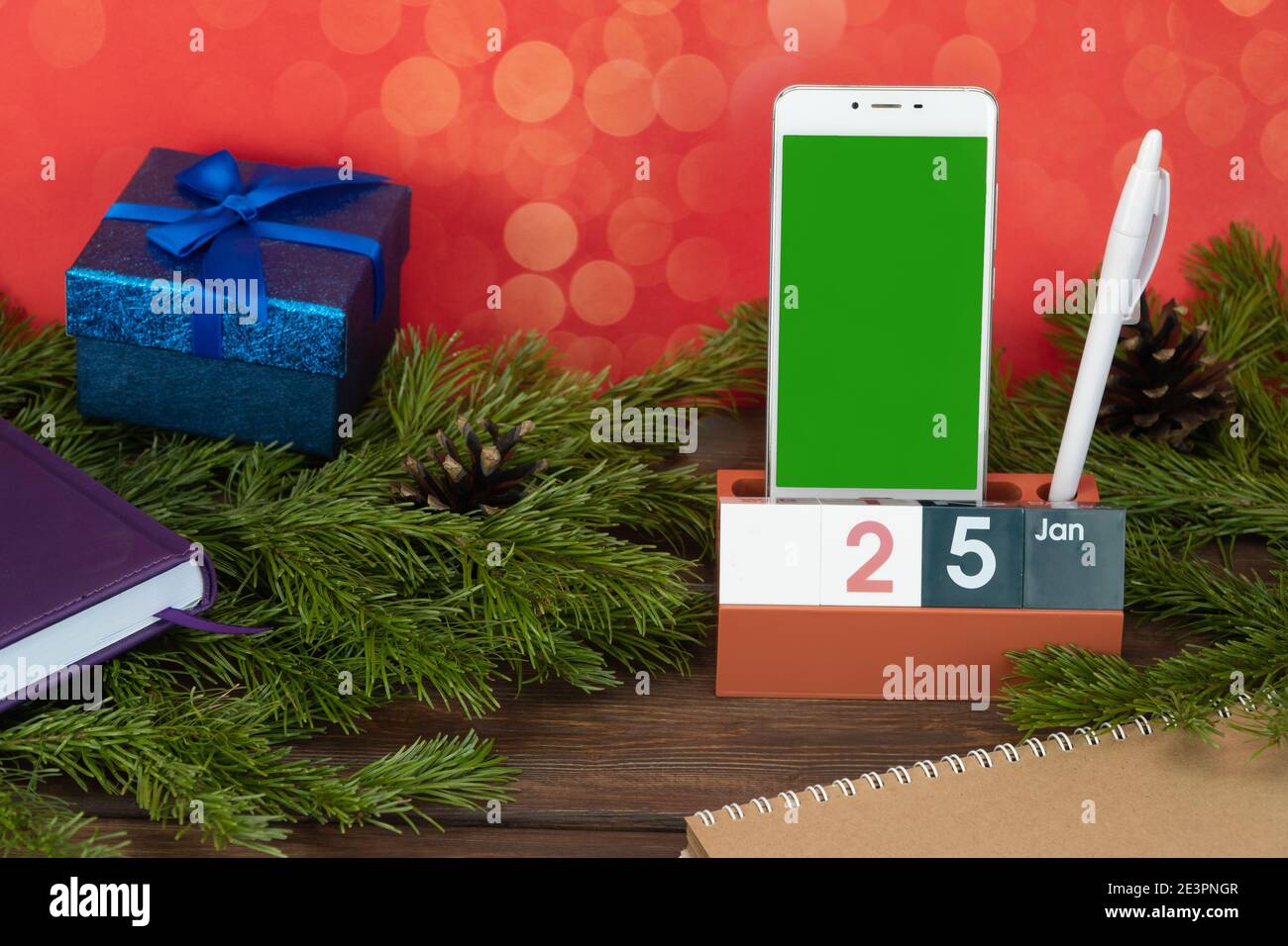 desktop calendar with the date January 25 and a cell phone. Plans for the day.  Stock Photo
