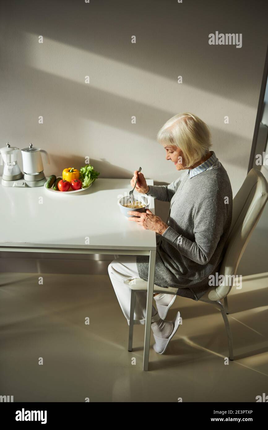 Smiling woman eating muesli in the morning Stock Photo