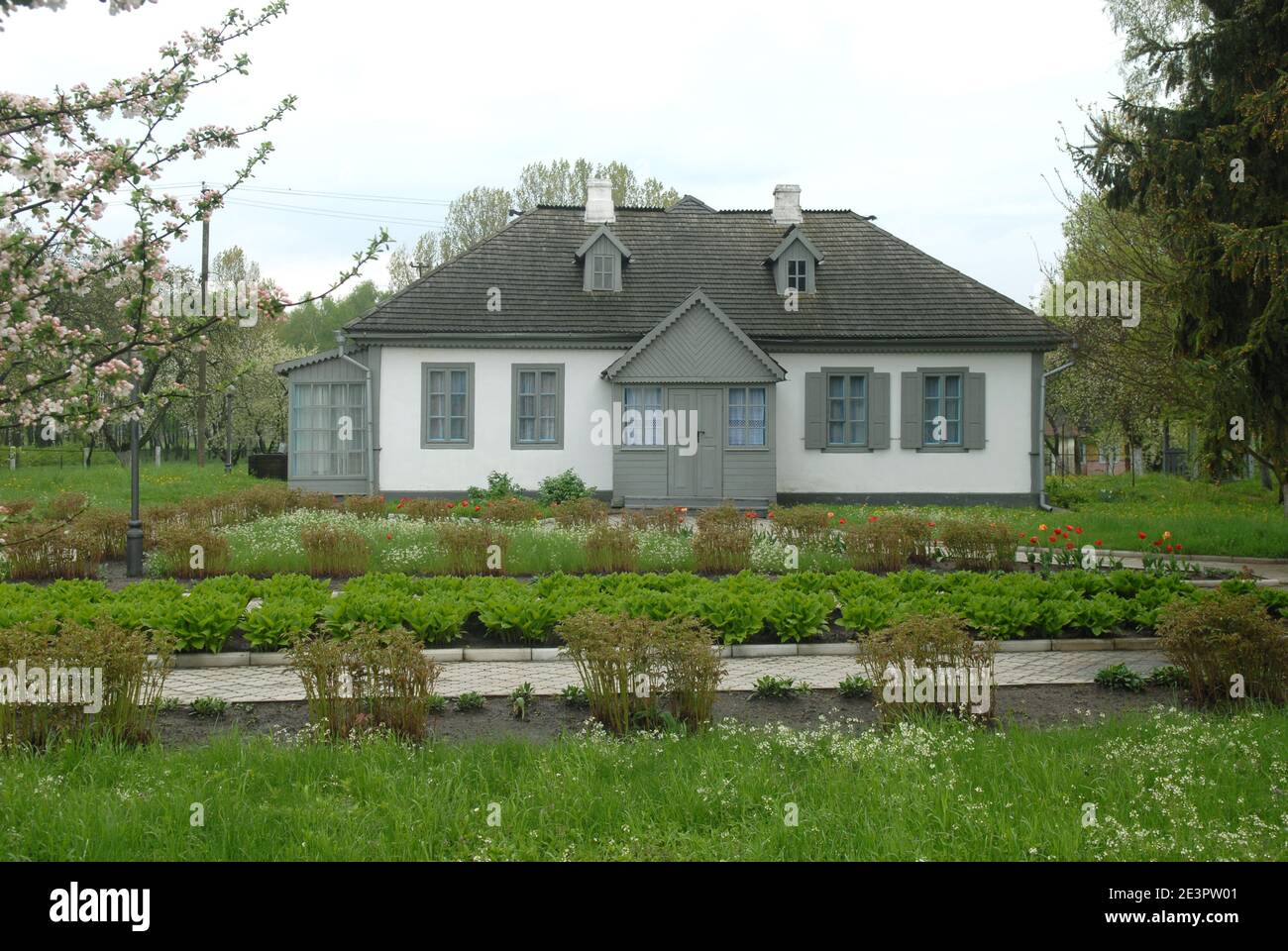 Grey house of Kosachy residense in Kolodiazhne. Green lawn in foreground. Stock Photo