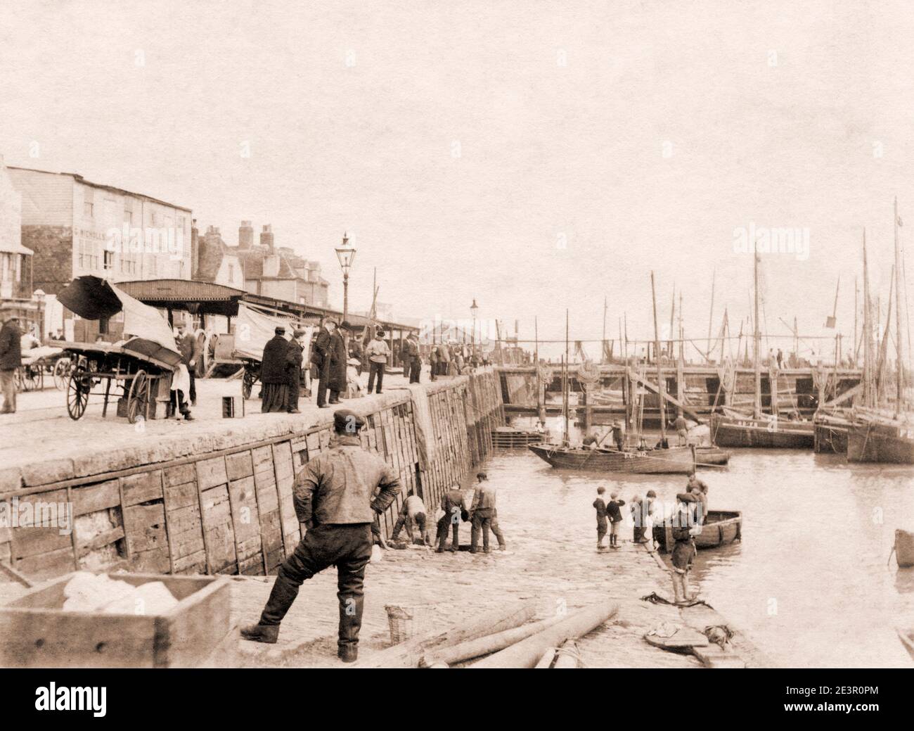 Fishing boats and quayside, Cullercoats, Northumberland, UK August 1897, building with name G. Nicholls sailmaker and ship chandler Stock Photo
