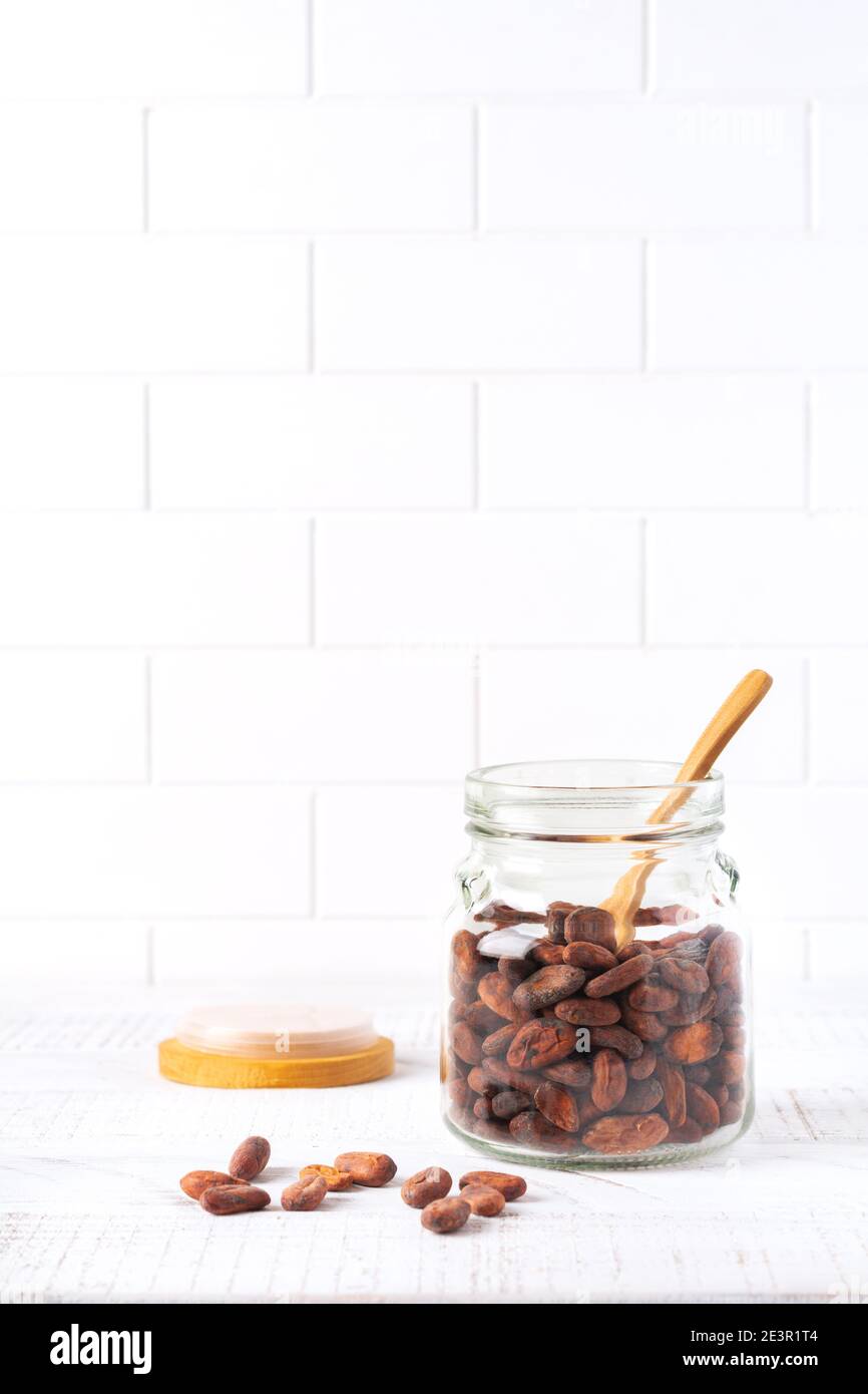 https://c8.alamy.com/comp/2E3R1T4/cocoa-beans-in-a-glass-jar-on-a-light-kitchen-table-culinary-food-cooking-background-for-making-traditional-chocolate-selective-focus-2E3R1T4.jpg