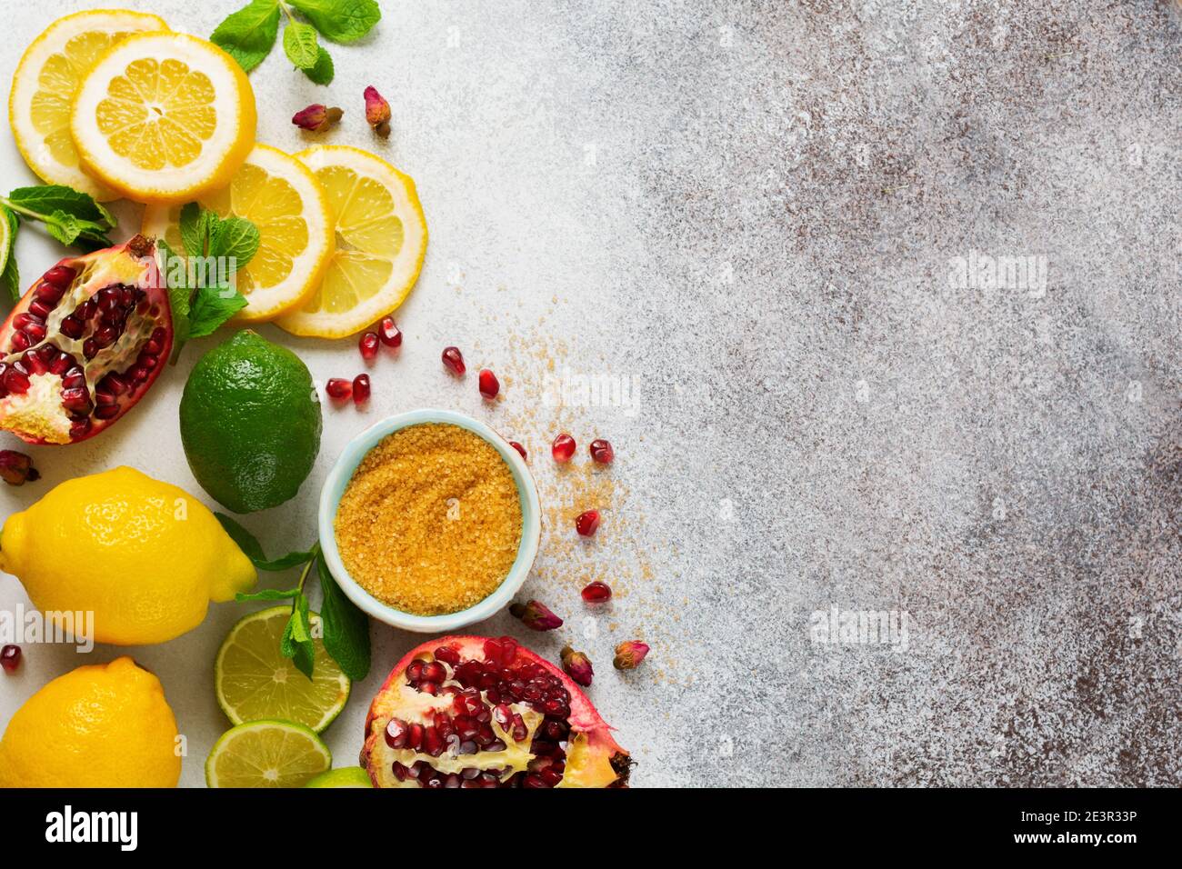 Culinary background for refreshing drinks lemonade, mojito or cold refreshing tea. Fresh lemon, lime, pomegranate, dried tea rose flowers, tea, cane s Stock Photo