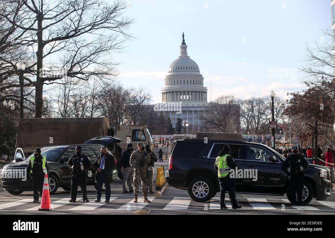 WASHINGTON, D.C., UNITED STATES - JANUARY 20, 2021: US National Guardsmen  and police officers stand on a closed street outside the Capitol Building.  The inauguration ceremony for US President-elect Joe Biden and