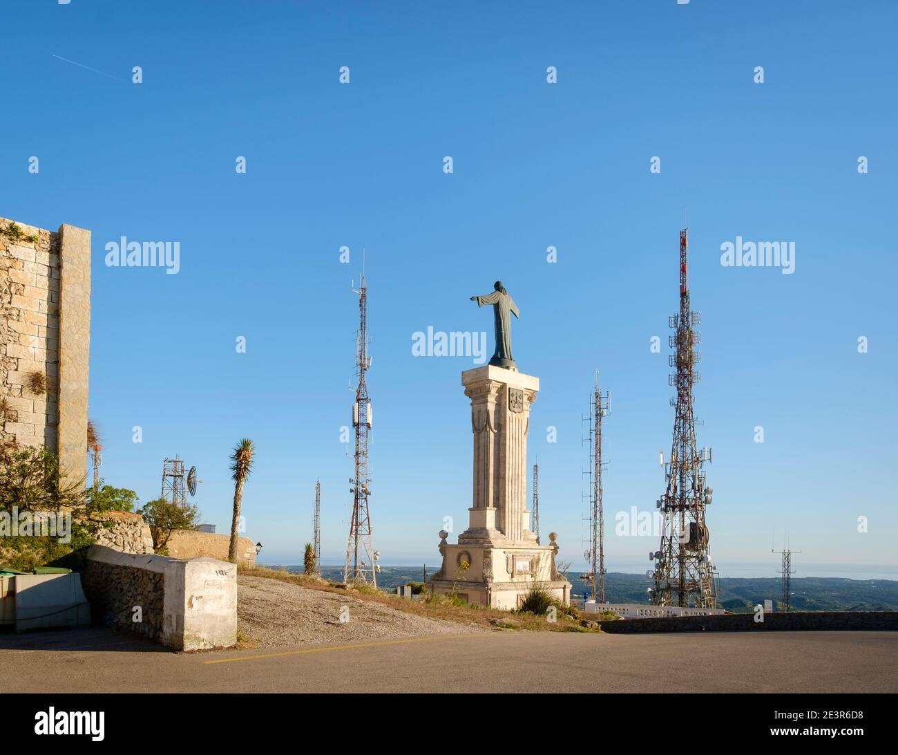 Jesus Christ statue surrounded by unsightly mobile phone transmitter masts on Mount Toro, the highest point on the island of Menorca, Spain Stock Photo