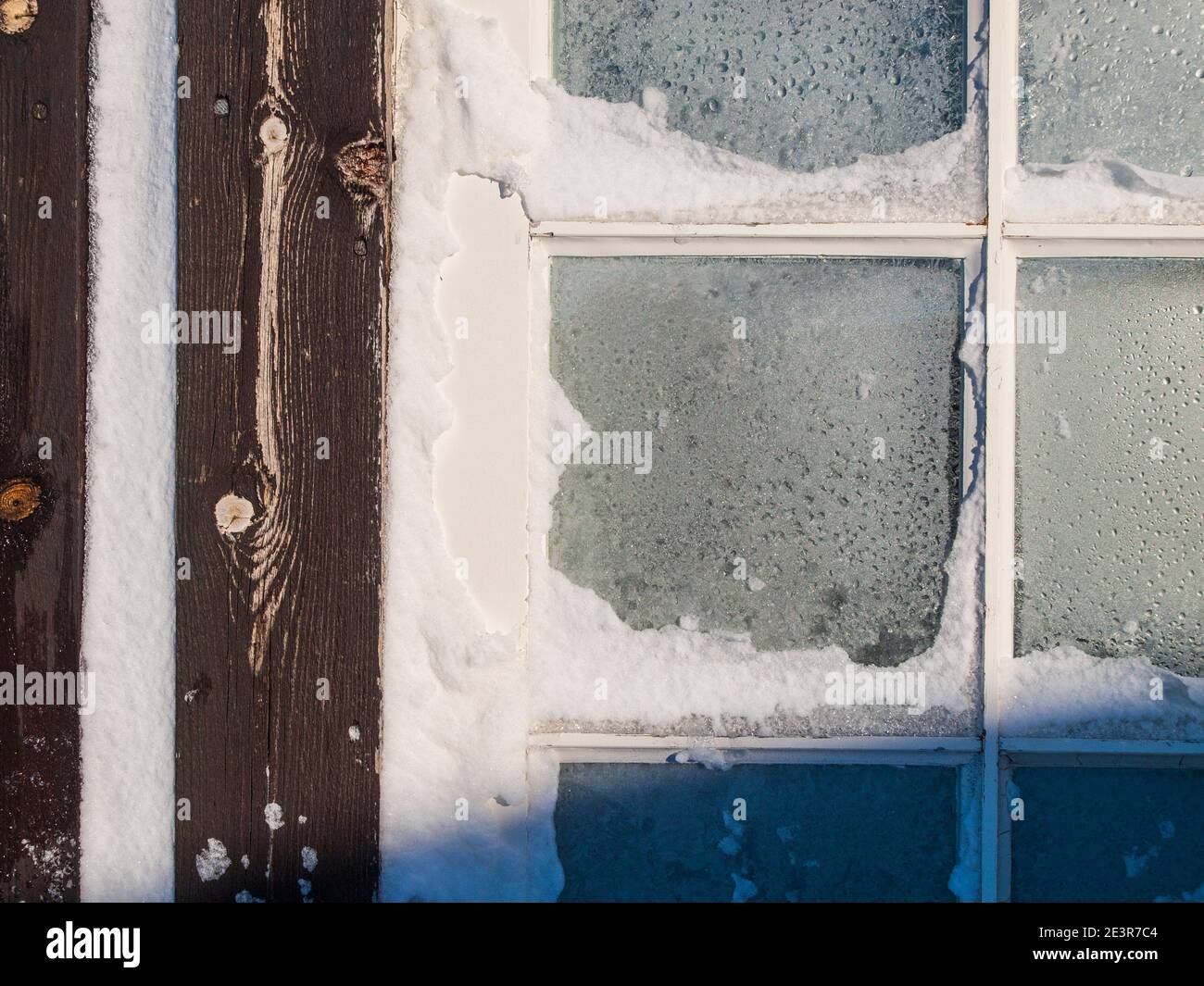 Frost and snow on a wooden window frame Stock Photo