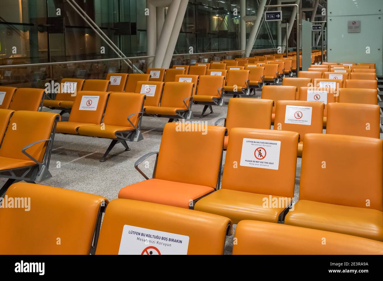 Signs on the chairs reminding about importance of social distancing during pandemic of Covid-19 Stock Photo
