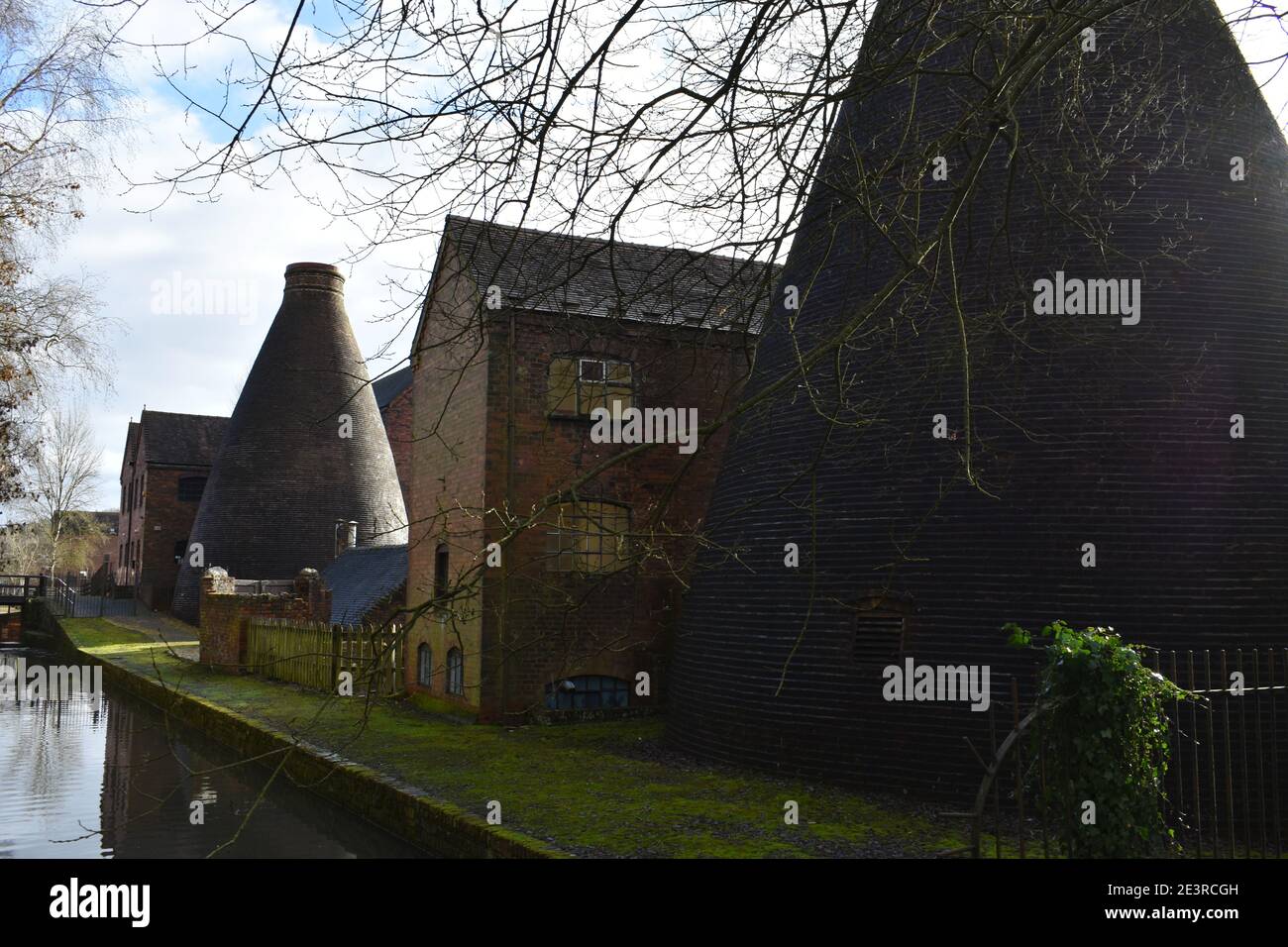 Brick built bottle kilns at Coalport china museum, Telford, Shropshire by a canal with reflections in water on a lovely sunny winter's day Stock Photo