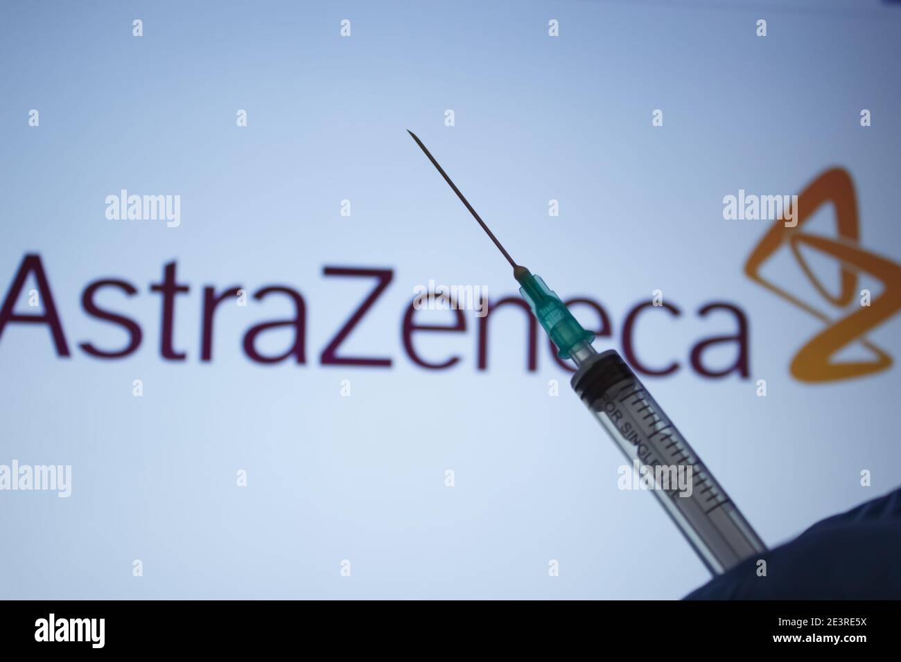 Covid-19 vaccine concept. Syringe needle, Blurred AstraZeneca company logo on the background. Coronavirus vaccination concept. Stock Photo