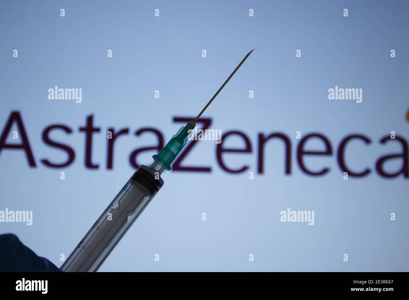 Covid-19 vaccine concept. Syringe needle, Blurred AstraZeneca company logo on the background. Coronavirus vaccination concept. Stock Photo