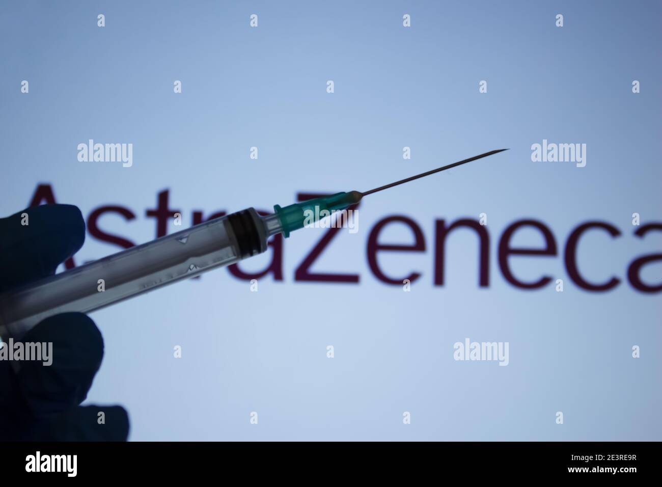 Covid-19 vaccine concept. Syringe needle, Blurred AstraZeneca company logo on the background. Coronavirus vaccination concept. Stock Photo