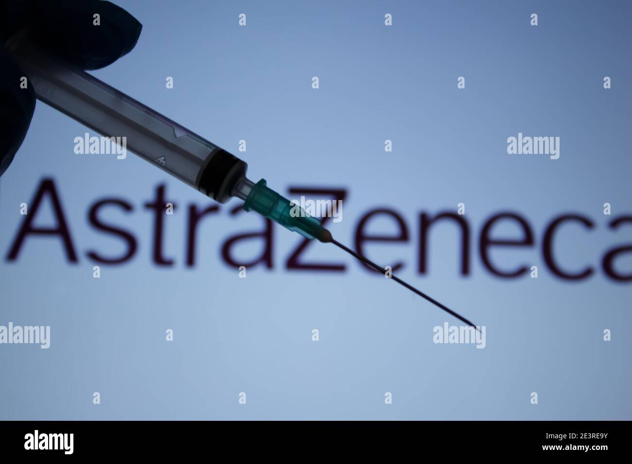 Covid-19 vaccine concept. Syringe needle, Blurred AstraZeneca company logo on the background. Coronavirus vaccination concept. Stock Photo