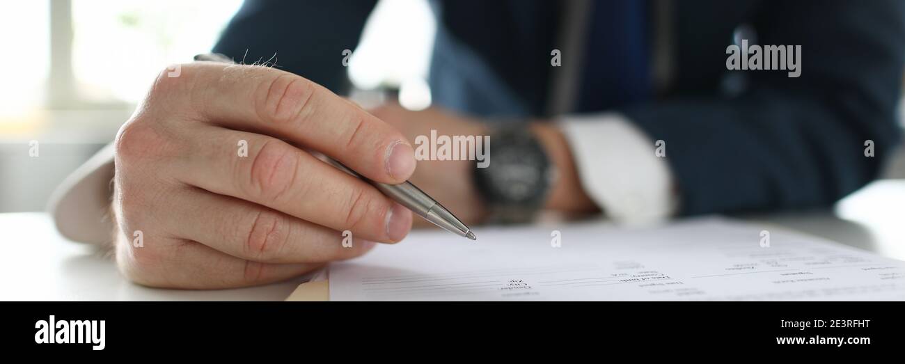 Man in a business suit sits in an office at table Stock Photo