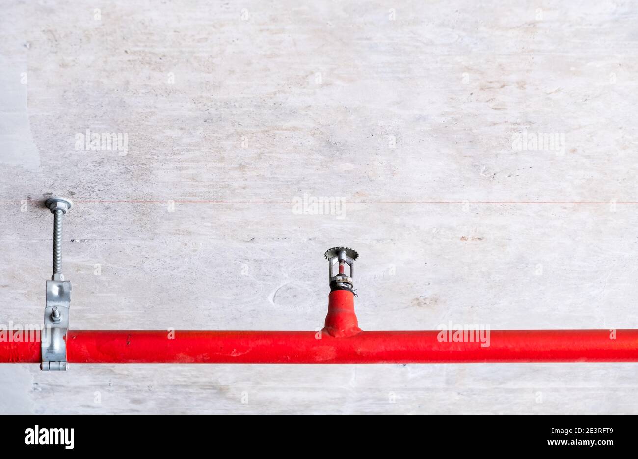 Automatic fire sprinkler on the red metal pipe of the fire protection