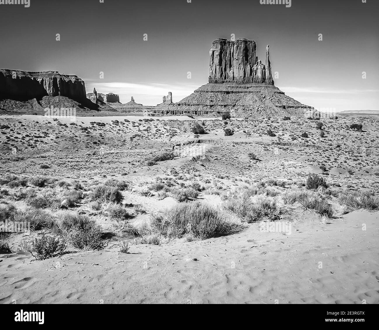United States. The fabulous mountain and desert scenery of Monument Valley in monochrome in the Monument Valley National Park of Arizona in the United States. Seen here from near John Ford Point overlook that was used during the epic filming of the attack and hair raising chase by so called hostile Red Indians of the six team horse driven Wells Fargo Stage Coach in the Western film Stagecoach that starred a very young up-coming actor called John Wayne, its a classic piece of movie making. Stock Photo
