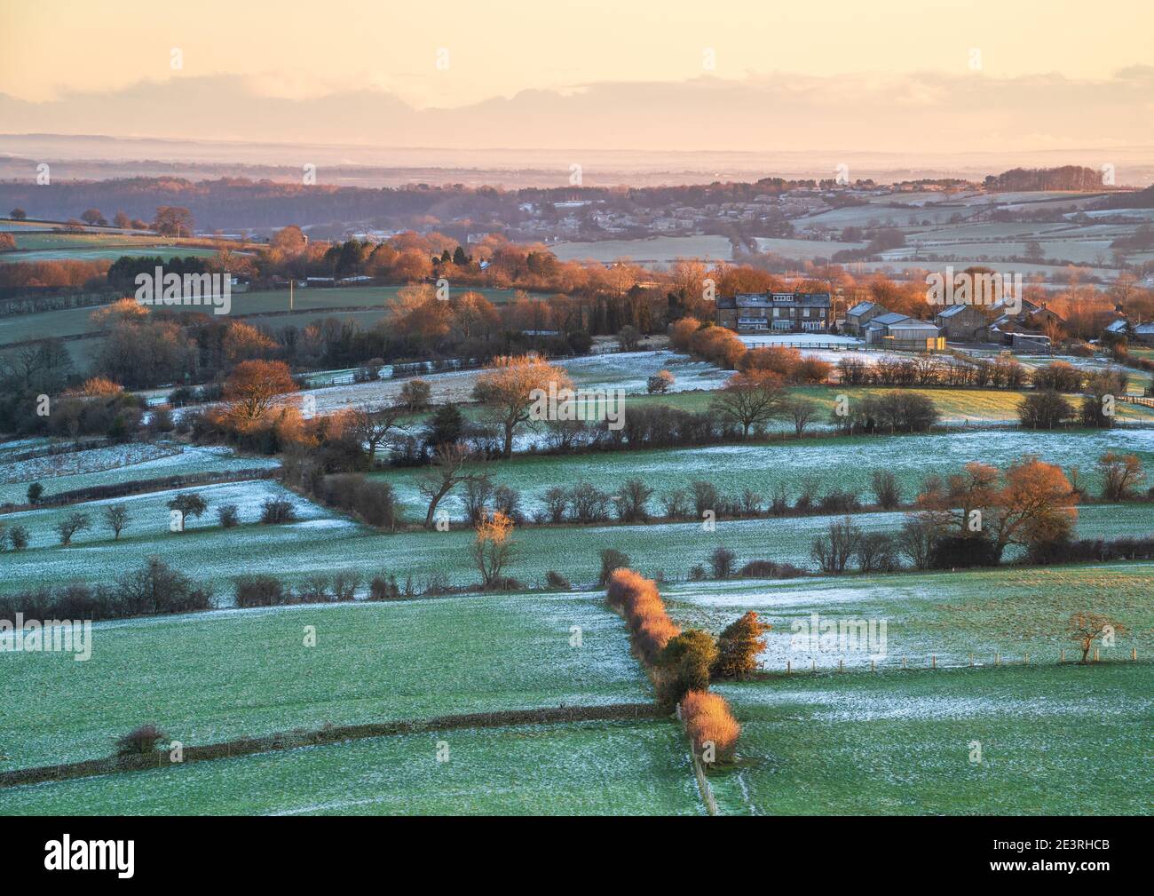 A light dusting of snow covers the landscape East of Almscliffe Crag in Lower Wharfedale as first light highlights the bitterly cold landscape. Stock Photo