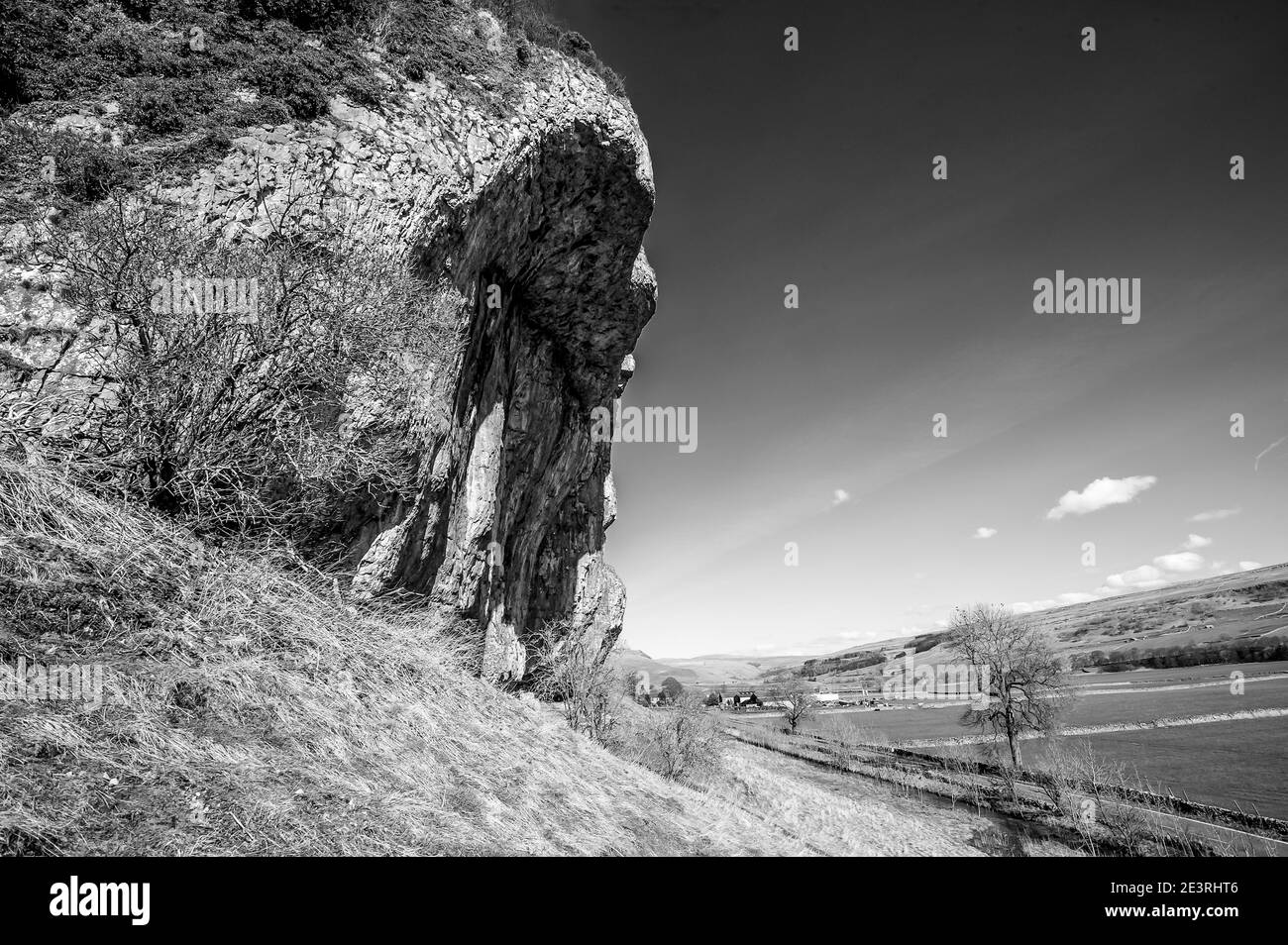 Fabulous spring scenery in monochrome of the overhanging limestone cliffs of Kilnsey Crag one of the famous geological features in the Yorkshire Dales near the villages of Kilnsey and Kettlewell Stock Photo