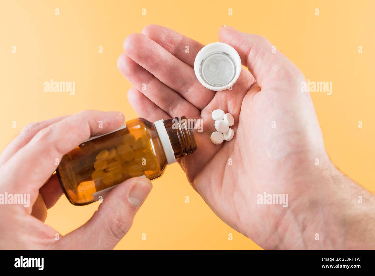 close-up of hands dispensing tablets from pill bottle, medication concept Stock Photo