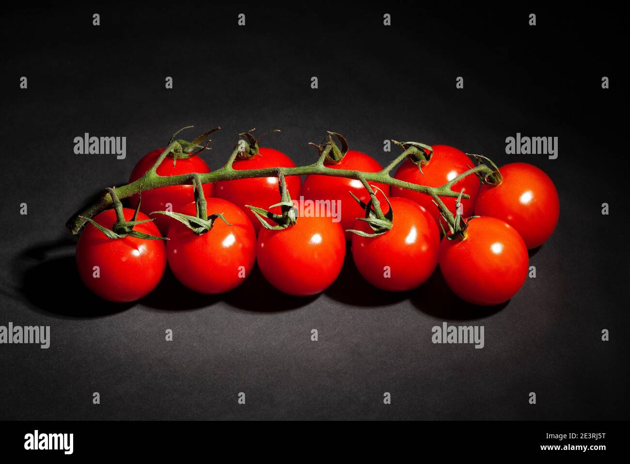 cherry tomato branch on black background Stock Photo