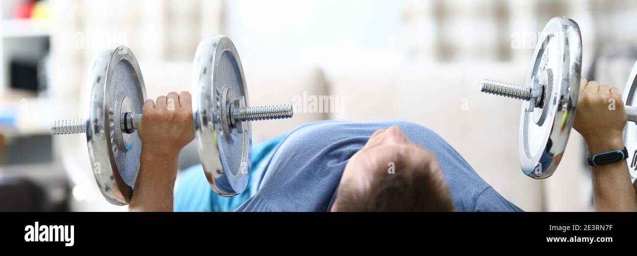 Muscular man lifting heavy dumbbells at home Stock Photo Alamy