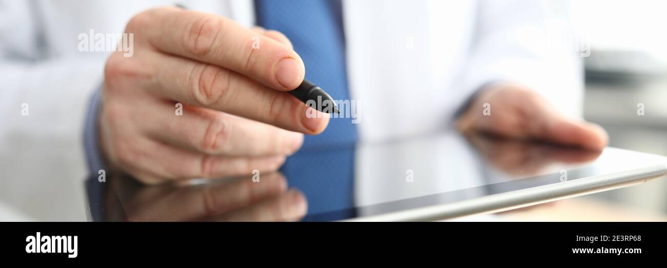 Doctor making notes on graphics tablet close up Stock Photo