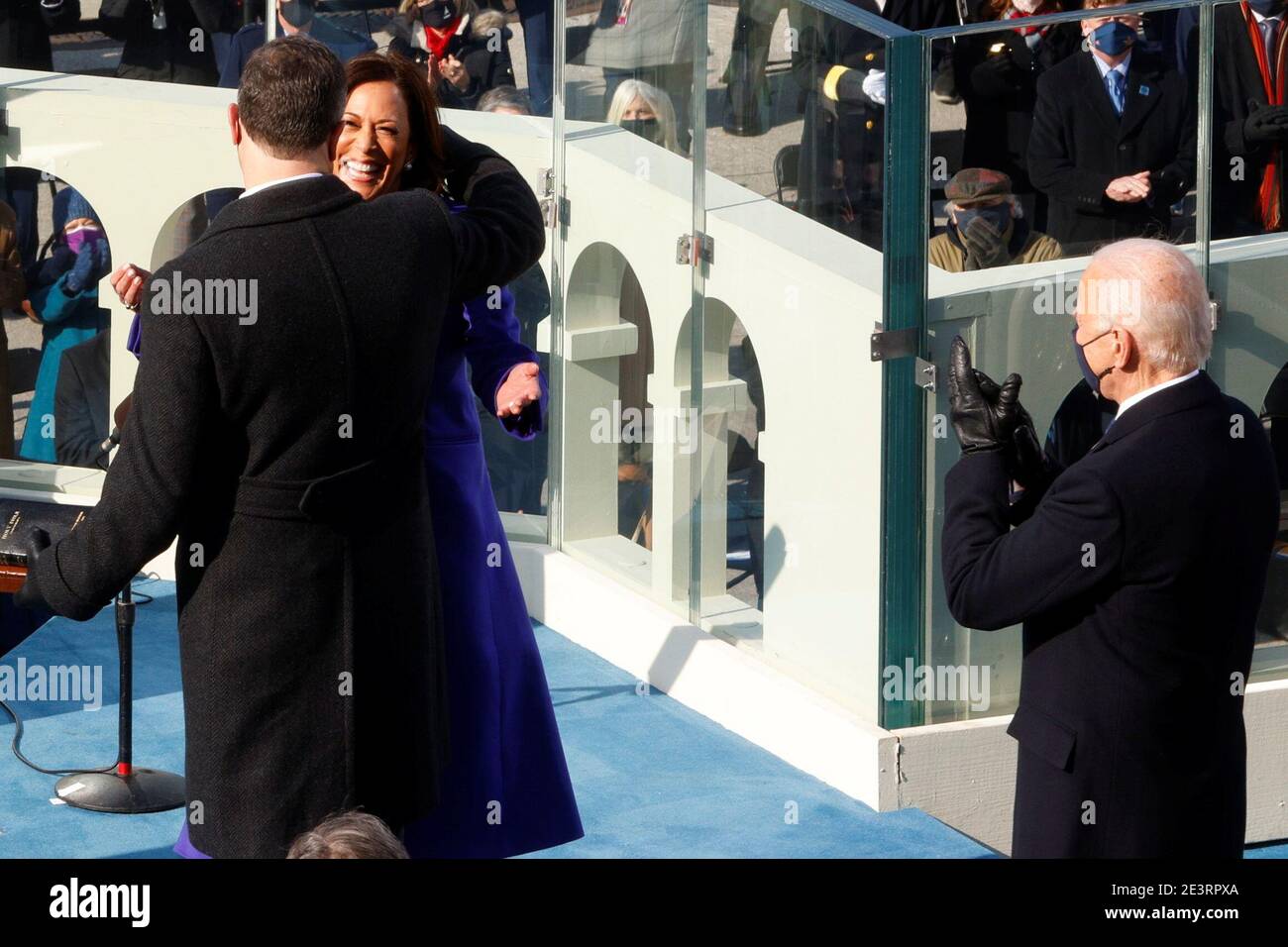 Kamala Harris is embraced by her husband Doug Emhoff as Joe Biden applauds, after her swearing-in during the inauguration of Joe Biden as the 46th President of the United States on the West Front of the U.S. Capitol in Washington, U.S., January 20, 2021. REUTERS/Jim Bourg Stock Photo