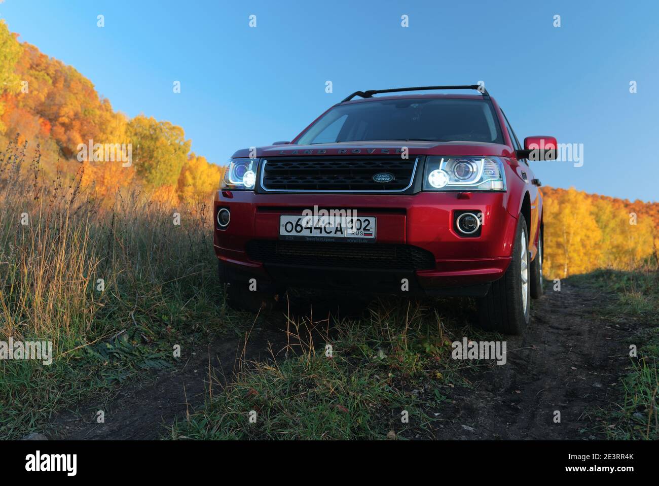 RUSSIA, Rep. of BASHKORTOSTAN, Kugarchinsky District, MRAKOVO village - SEPTEMBER 27, 2020. A red LAND ROVER FREELANDER 2 SUV stands on a dirt road in Stock Photo