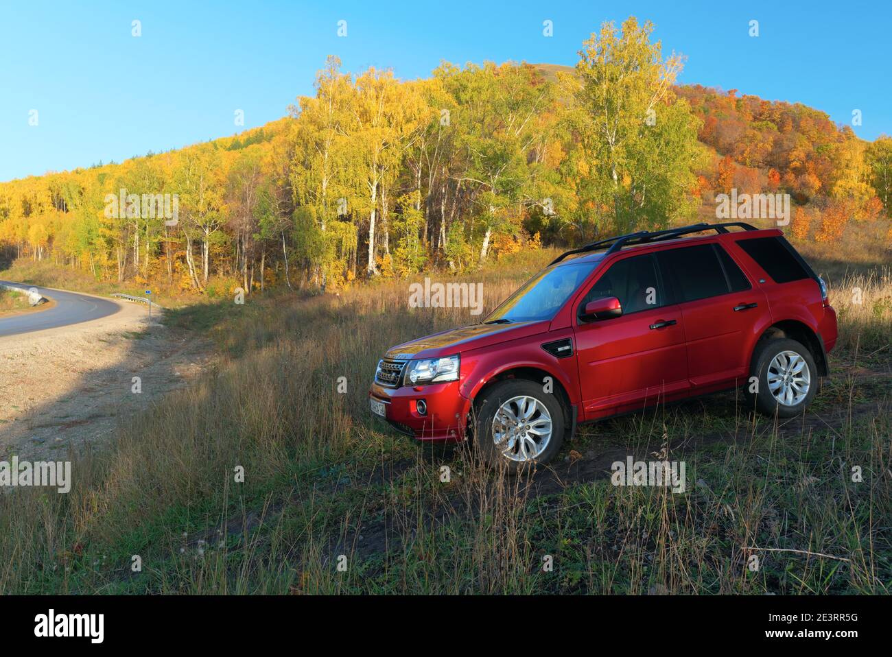 RUSSIA, Rep. of BASHKORTOSTAN, Kugarchinsky District, MRAKOVO village - SEPTEMBER 27, 2020. A red LAND ROVER FREELANDER 2 SUV stands on a dirt road, i Stock Photo