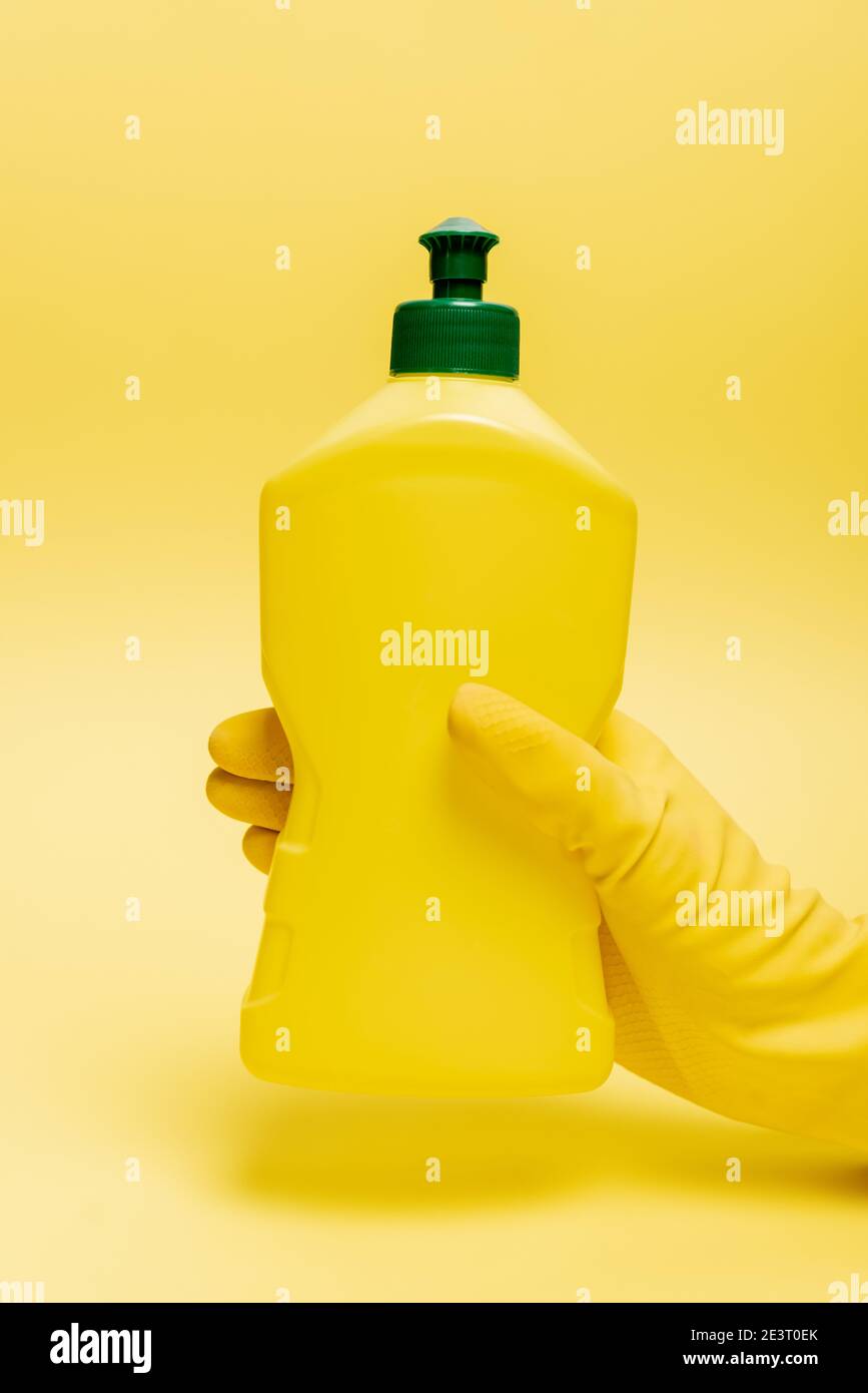 https://c8.alamy.com/comp/2E3T0EK/cropped-view-of-hand-in-rubber-glove-holding-bottle-of-dishwashing-liquid-on-yellow-background-2E3T0EK.jpg
