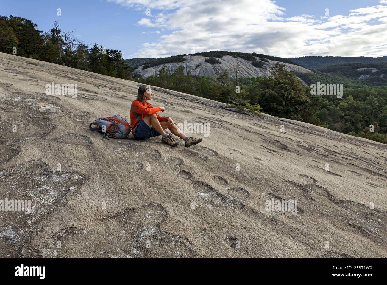 NC00381-00...NORTH CAROLINA - Hiker on Cedar Rock with Stone Mountain in the distance, Stone Mountain State Park. (MR# K1) Stock Photo