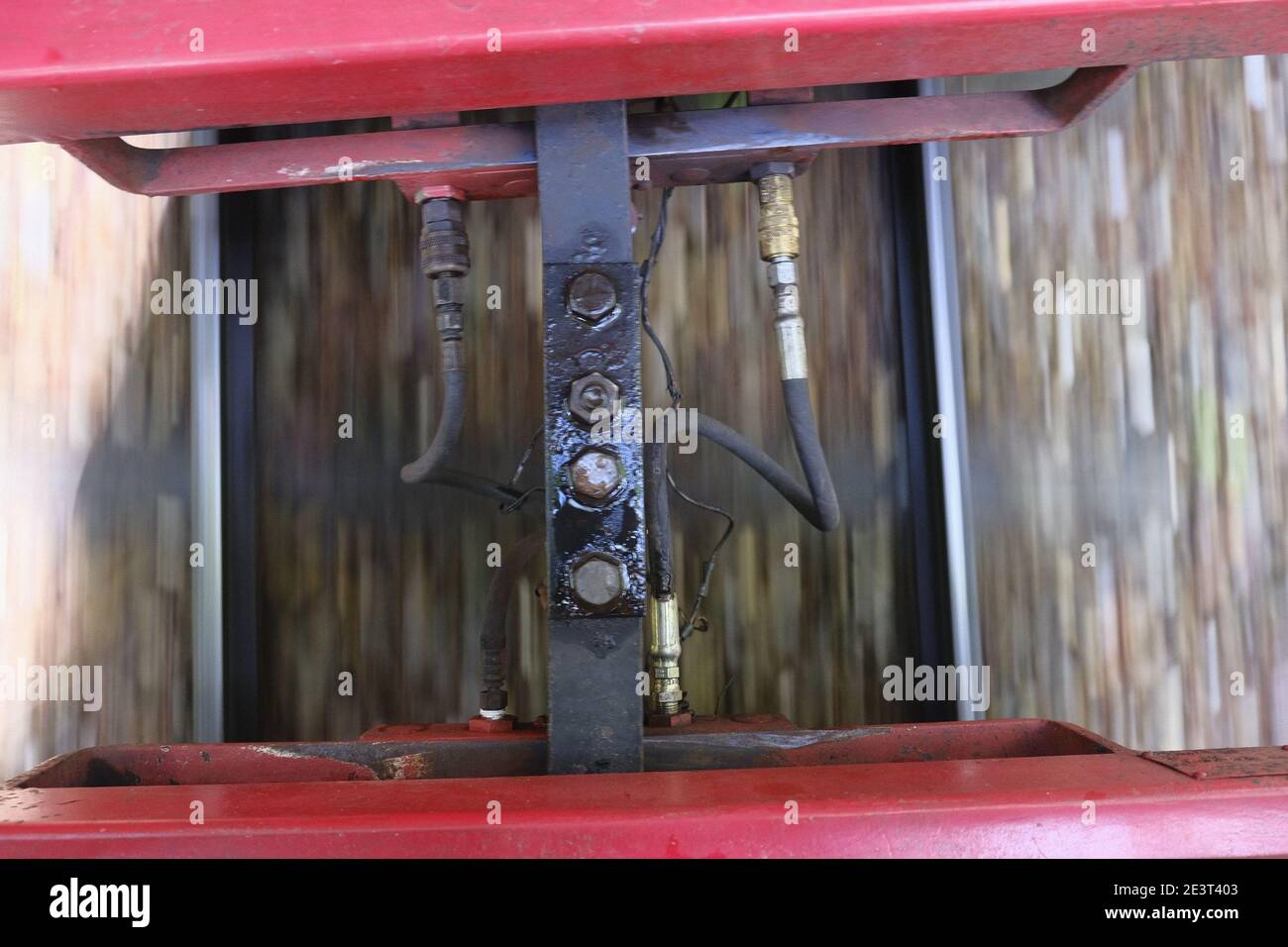 the connection between two red train cars in motion Stock Photo