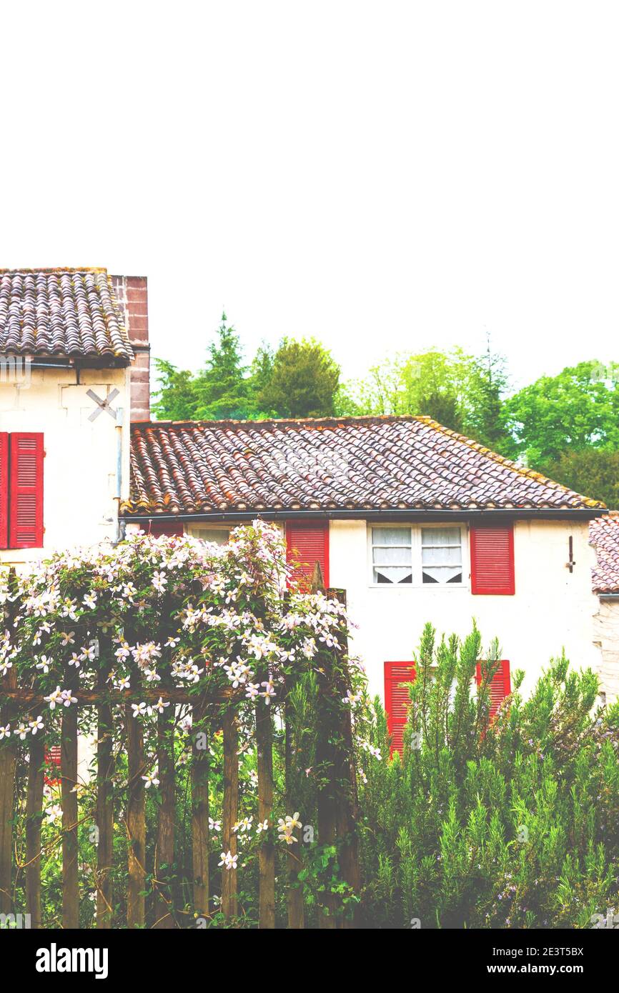 French countryside. Typical stone house with red wooden shutters and ...