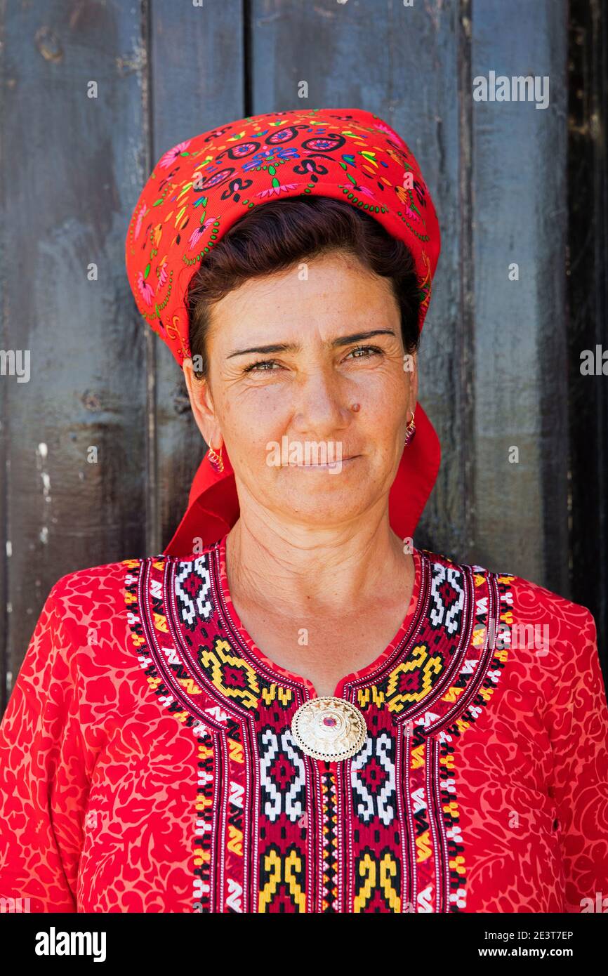 Close-up portrait of Turkmen woman wearing red headscarf and koynek, traditional long dress with embroidery, Turkmenistan Stock Photo