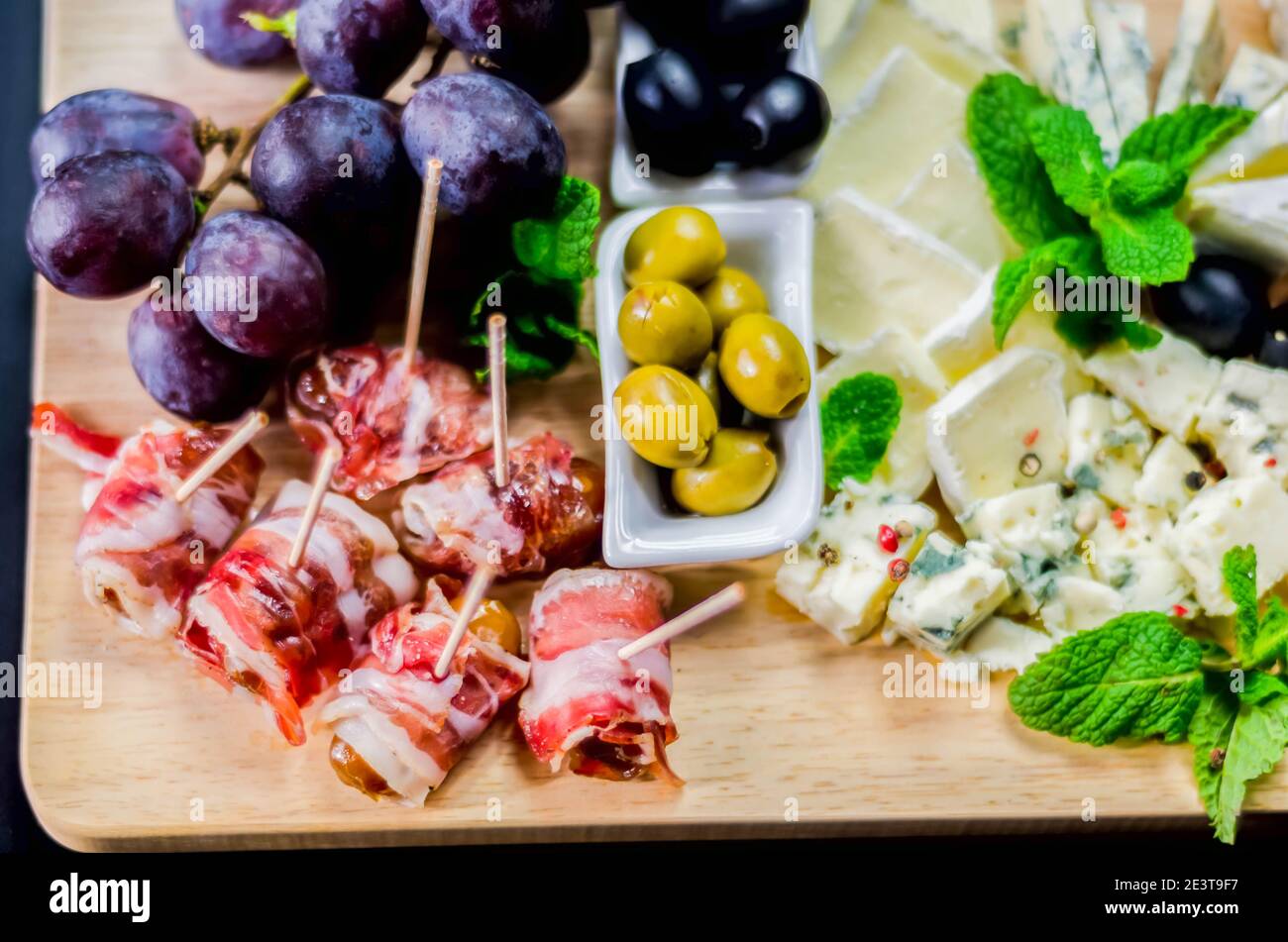 Delicious figs wrapped in bacon served with blue cheese, grapes and