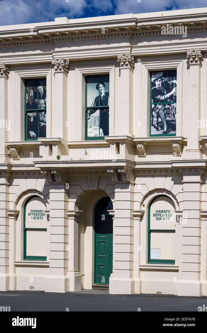 The circa 1870 Oamaru Repertory Society building, recently renovated, Oamaru, South Island, New Zealand. Historic theatrical figures in upper windows. Stock Photo