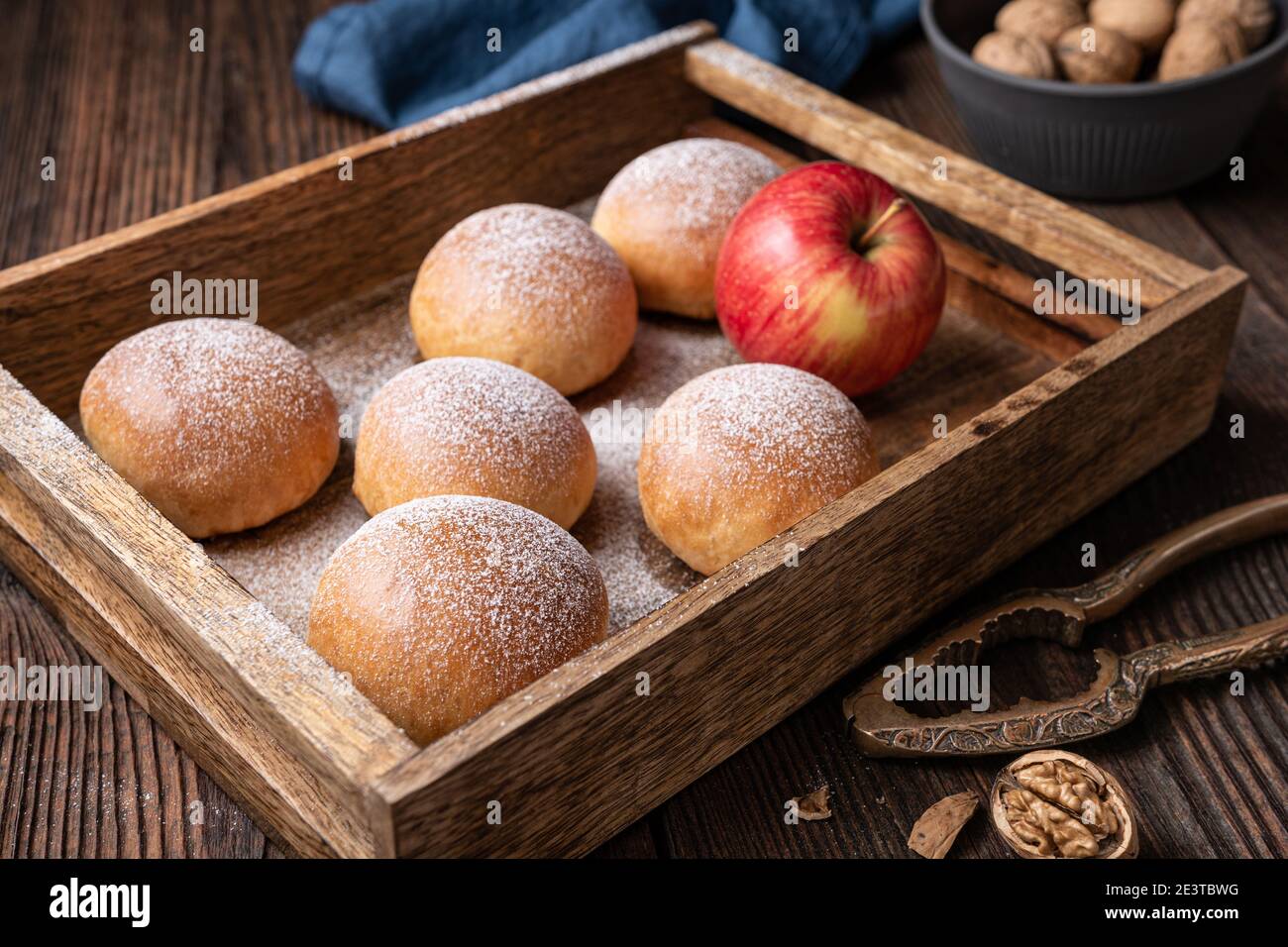 Delicious sweet pastry, baked buns with apple and walnut filling, sprinkled with powdered sugar Stock Photo