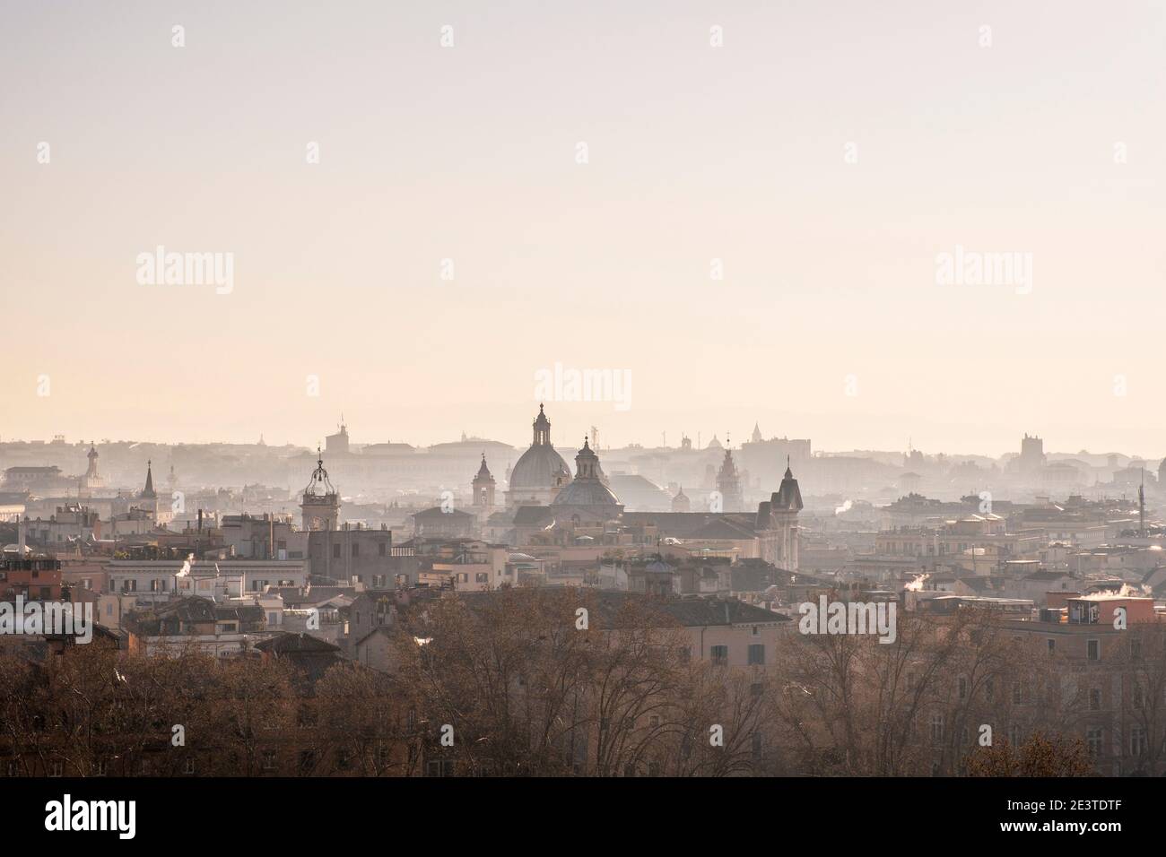 Atmospheric view down onto the misty outlines of domes, churches, landmark buildings and rooftops of central Rome, Italy, from Trastevere, at sunrise Stock Photo