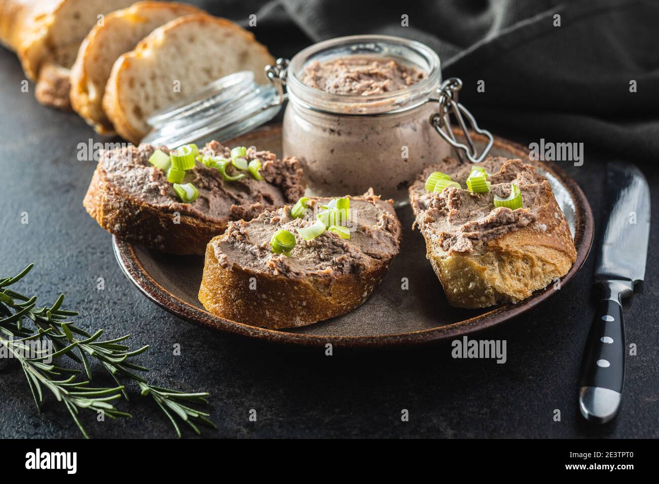 Liver pate on sliced baguette on plate. Stock Photo