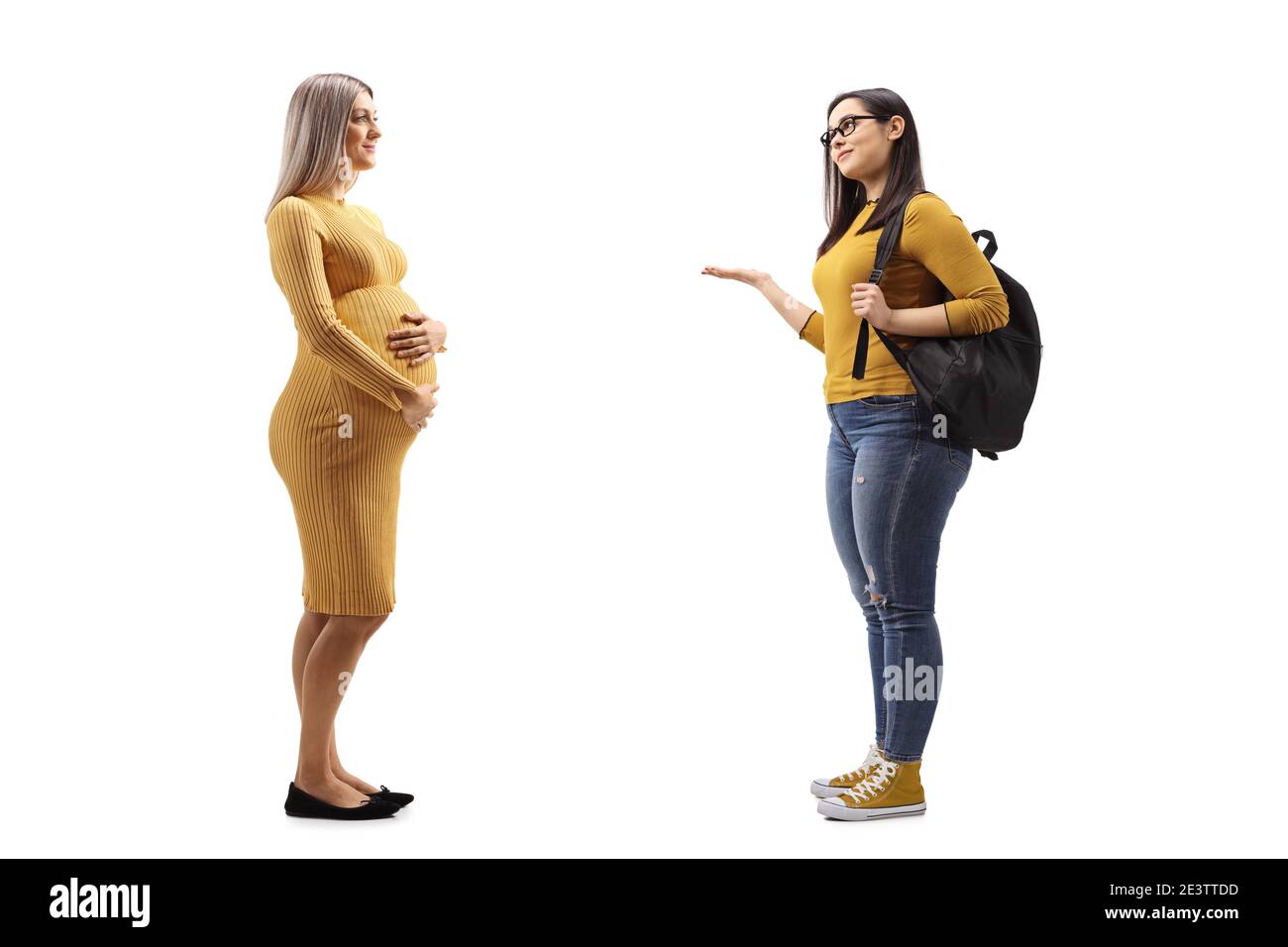 Full length profile shot of a pregnant woman and a female student having a conversation isolated on white background Stock Photo