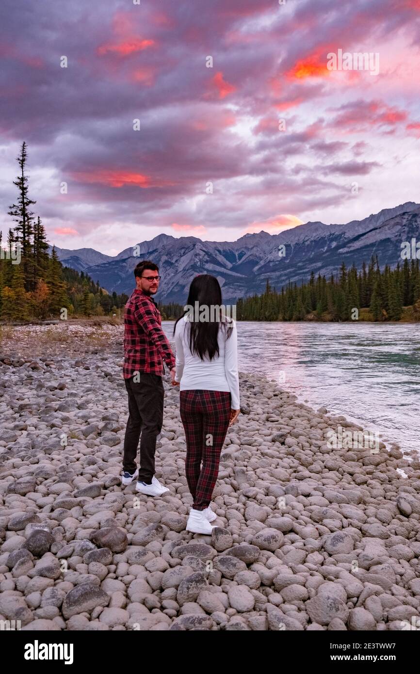 couple men and woman mid age looking sunrise by the bow river Jasper National park Canadian Rockies. High quality photo Stock Photo