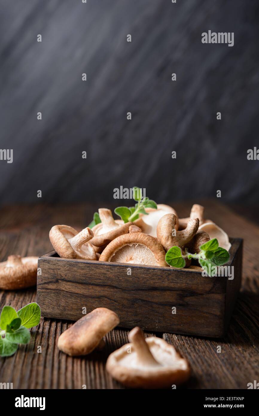 Heap of immunity boosting fresh Shiitake mushrooms in a bowl on rustic wooden background with copy space Stock Photo