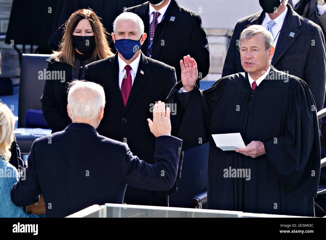 Washington, DC. 20th Jan, 2021.John Roberts, chief justice of the U.S. Supreme Court, right, administers the oath of office to U..S. President-elect Joe Biden, second left, during the 59th presidential inauguration in Washington, D.C., U.S., on Wednesday, Jan. 20, 2021. Biden will propose a broad immigration overhaul on his first day as president, including a shortened pathway to U.S. citizenship for undocumented migrants - a complete reversal from Donald Trump's immigration restrictions and crackdowns, but one that faces major roadblocks in Congress. Photographer: Kevin Dietsch/UPI | usage wo Stock Photo